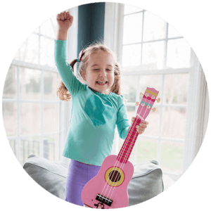 huge cropped image of a happy girl in green long sleeved top and violet jeans while holding a pink ukelele