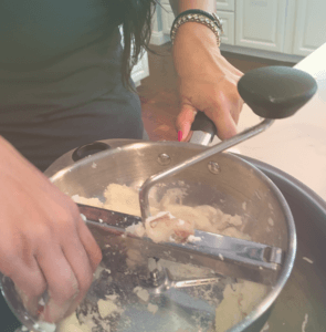 image of a woman's hands inside a potato masher bowl